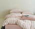 Cotton Quilt Cover Set featuring soft pink striped design on a cozy bed with pillows and a magazine.
