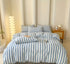 Cotton Quilt Cover Set featuring blue and white stripes on a neatly made bed with decorative pillows.
